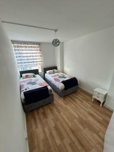 a bedroom with two beds and a window at 2 Bedrooms. London Skyline view 3 beds and balcony in London