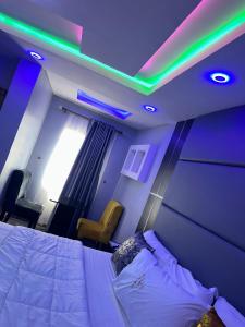una camera con letto e illuminazione verde e viola di TM Royal Hotel, Ibadan a Ibadan