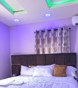una camera da letto con un grande letto con pareti viola di TM Royal Hotel, Ibadan a Ibadan