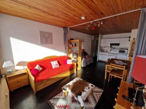 尚魯斯的住宿－Résidence LES CHAMOIS Pied des pistes Chamrousse，一间带红色沙发的客厅和一间厨房