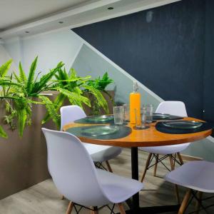 a dining room table with white chairs and a table with plates at Stylish studio apartment in Quito