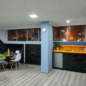 a kitchen with black cabinets and a table and chairs at Stylish studio apartment in Quito