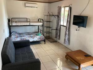 a living room with a couch and bunk beds at Pura Natura Lodge Manuel Antonio in Manuel Antonio