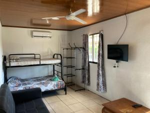 a room with two bunk beds and a flat screen tv at Pura Natura Lodge Manuel Antonio in Manuel Antonio