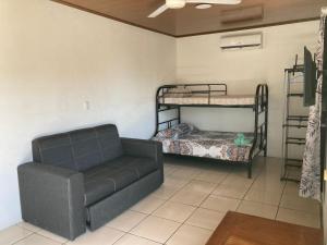 ein Wohnzimmer mit einem Sofa und Etagenbetten in der Unterkunft Pura Natura Lodge Manuel Antonio in Manuel Antonio