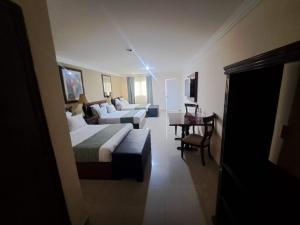 a hotel room with two beds and a couch at Hotel Confort Plaza in Culiacán
