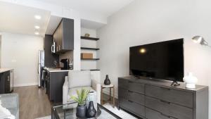 een woonkamer met een grote flatscreen-tv bij Landing - Modern Apartment with Amazing Amenities (ID8555X85) in Lewinsville