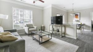 uma sala de estar com um sofá e uma televisão de ecrã plano em Landing - Modern Apartment with Amazing Amenities (ID1375X557) em Wake Forest