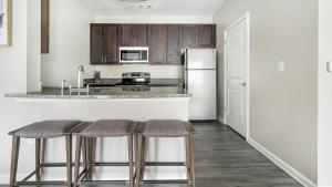 cocina con barra y 2 taburetes en Landing - Modern Apartment with Amazing Amenities (ID1375X557) en Wake Forest