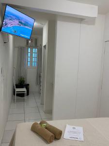 布希奧斯的住宿－Caminho das Pedras Búzios，配有电视和一张带毛巾的桌子的房间