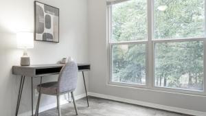 einen Schreibtisch und einen Stuhl in einem Zimmer mit Fenster in der Unterkunft Landing - Modern Apartment with Amazing Amenities (ID9232X12) in Forest Park