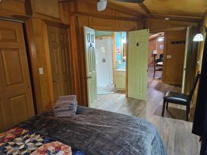 ein Schlafzimmer mit einem Bett in einem Zimmer mit Holzwänden in der Unterkunft Frog Hollow at Hocking Vacations in Logan
