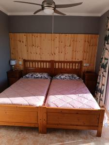 a bedroom with a wooden bed with a ceiling fan at Hostal Bélgica in Palmanova