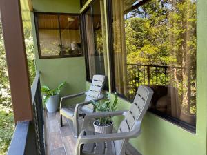 two white chairs sitting on a screened porch at Caba&ntilde;as La Monta&ntilde;a Mountain Lodge in Monteverde Costa Rica