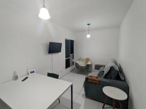 uma sala de estar com um sofá e uma mesa em Apartamento, 2 quartos com piscina em Paulista