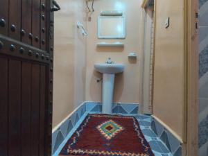 a bathroom with a sink and a toilet with a rug at Nomad Bivouac in Merzouga