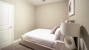 een witte slaapkamer met een bed en een toilet bij Landing - Modern Apartment with Amazing Amenities (ID7788X51) in Greenville