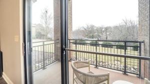 Habitación con balcón con 2 sillas y ventana. en Landing - Modern Apartment with Amazing Amenities (ID7788X51), en Greenville