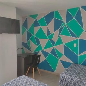 a bedroom with a blue and green wall with a desk at Perfect Suite, near everything! ¡cerca de todo! in Quito