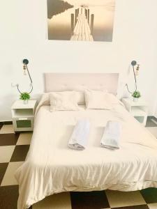 a bedroom with a white bed with two towels on it at LOS ROSALES in Alcaracejos