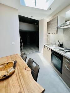 een keuken met een houten tafel in het midden bij Appartement tropical in Luik