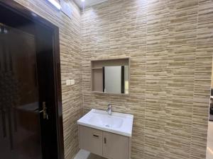 uma casa de banho com um lavatório e um espelho em الوسام شقه فندقيه 3 غرف نوم وصاله Al Wissam contains 3 bedrooms and a living room em Taif