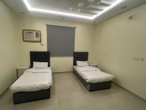 um quarto com duas camas num quarto em الوسام شقه فندقيه 3 غرف نوم وصاله Al Wissam contains 3 bedrooms and a living room em Taif