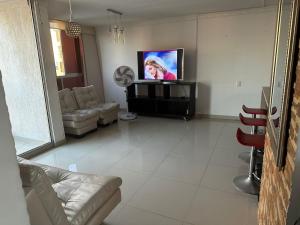 sala de estar con TV de pantalla plana y sofá en Apartamento, en las mejores zonas de Barranquilla, en Barranquilla