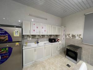 uma cozinha com armários brancos e um frigorífico em الوسام شقه فندقيه 3 غرف نوم وصاله Al Wissam contains 3 bedrooms and a living room em Taif