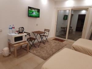 a living room with a microwave and a table with chairs at Fantastic new rooms close to New Cairo Festival City and airport in Cairo