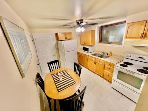 eine kleine Küche mit einem Holztisch und Stühlen in der Unterkunft Cozy 2BR Basement Apt in Newmarket in Newmarket