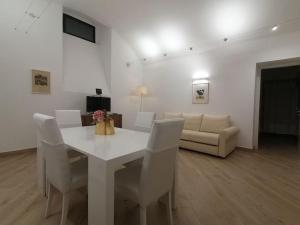 ein weißes Esszimmer mit einem weißen Tisch und weißen Stühlen in der Unterkunft MOLO 7 - ANTESITUM - classic, modern and cozy in Malgrate