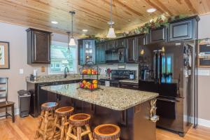a kitchen with a large island with bar stools at Almost Bearadise Brand New 5 Bedroom Home with Views in Black Mountain