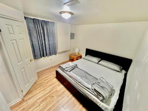 Schlafzimmer mit einem Bett, einem Fenster und einer Tür in der Unterkunft Cozy 2BR Basement Apt in Newmarket in Newmarket