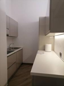 eine Küche mit weißen Schränken und einer weißen Arbeitsplatte in der Unterkunft MOLO 7 - ANTESITUM - classic, modern and cozy in Malgrate