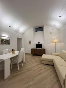 ein weißes Wohnzimmer mit einem Sofa und einem Tisch in der Unterkunft MOLO 7 - ANTESITUM - classic, modern and cozy in Malgrate