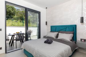 ein Schlafzimmer mit einem Bett mit blauem Kopfteil in der Unterkunft Vila Petram in Bribir + 50 Fotos