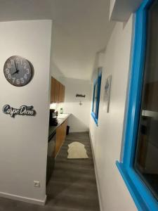 a hallway with a clock on the wall and a kitchen at Krutenau Lifestyle in Strasbourg