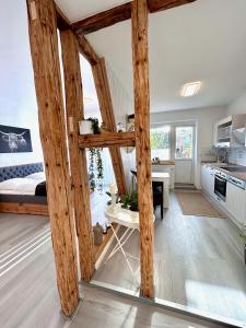 a room with wooden beams and a kitchen with a bed at Ferienwohnung Johanna in Naumburg