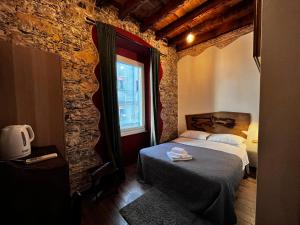 a bedroom with a bed in a room with a brick wall at La Taverna del Metallo Rooms in La Spezia