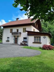 una casa blanca con un banco delante en Landhaus Nikki, en Gmünd in Kärnten