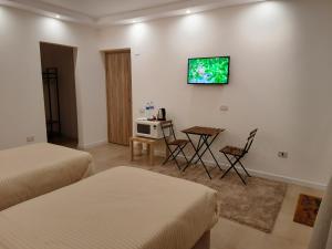 Habitación con 2 camas, mesa y TV. en Fantastic new rooms close to New Cairo Festival City and airport en El Cairo