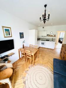 a living room with a dining table and a kitchen at Apartament Jan III Sobieski in Rzeszów