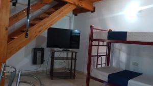 a room with two bunk beds and a flat screen tv at Aires de Montaña in Malargüe
