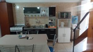 a kitchen with a table and a white refrigerator at Aires de Montaña in Malargüe +8 photos