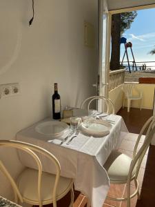 a white table with a bottle of wine and chairs at Veuràs el Mar - Madrague Beach Studio 25 in Roses