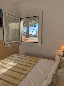 a bedroom with a window with a bed and a playground at Veuràs el Mar - Madrague Beach Studio 25 in Roses