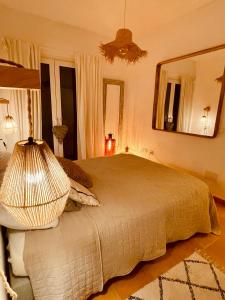 1 dormitorio con 1 cama grande y espejo grande en Can Somni - Appartement bohème, zen et chic avec piscine, en Cala Figuera
