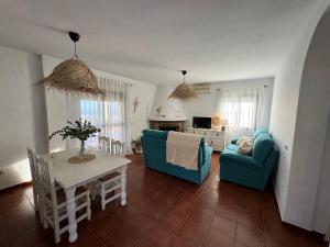 a living room with a blue couch and a table at Villa en Frigiliana con piscina, jacuzzi y espectaculares vistas in Frigiliana