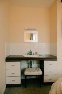 a bathroom with a counter with a sink and a stool at Granary at Tyddyn Isaf in Ruthin